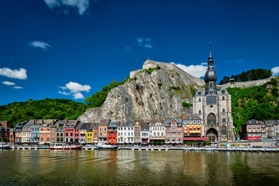 Buildings by river against sky