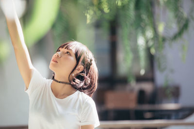 Young woman looking up outdoors