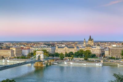 View of budapest with st. stephen's basilica and szechenyi chain bridge at sunset, hungary