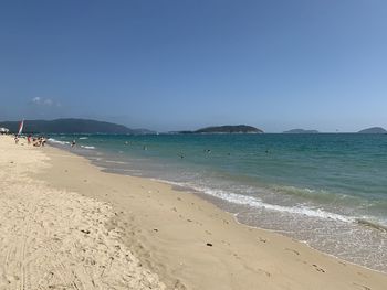 Scenic view of beach against clear blue sky