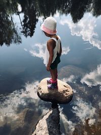 Girl standing on rock at lake