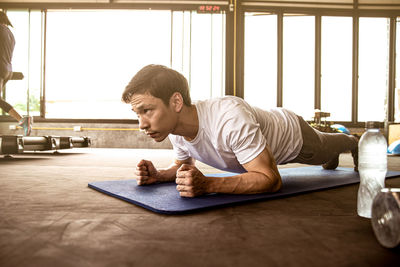 Full length of young man sitting on window