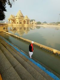 High angle view of man standing by lake against temple