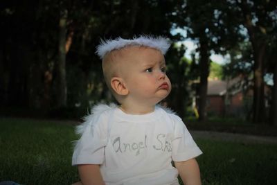 Baby in angel costume sitting in park
