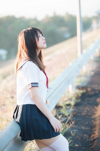 Woman in uniform leaning on railing