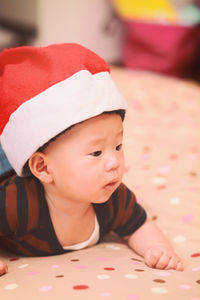 Close-up of cute baby boy wearing santa hat while playing at home