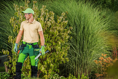 Rear view of man standing amidst plants