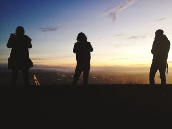 Silhouette man standing against sky at sunset