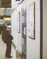 Rear view of people looking at railroad station