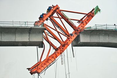 Low angle view of crane against sky