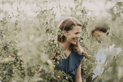 Rear view of mother and daughter against plants