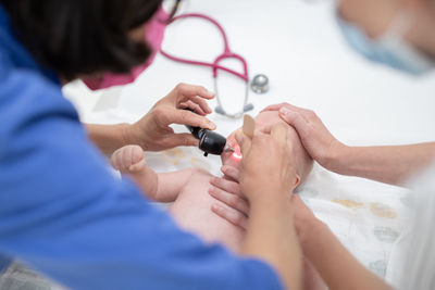 Midsection of doctor examining patient in hospital