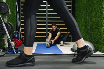 Close-up of a young man stretching in the gym