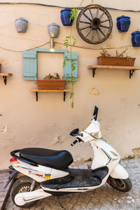 Motor scooter on wall by house at home