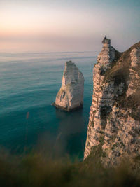 Rock formation in sea against sky