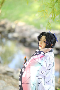 Portrait of young woman looking away while standing outdoors