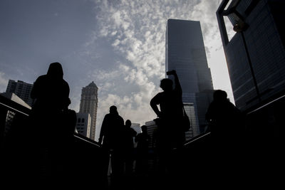 Low angle view of silhouette man standing in city