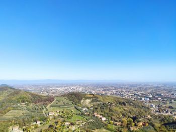 Aerial view of townscape against clear blue sky