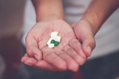 Midsection of man holding pills