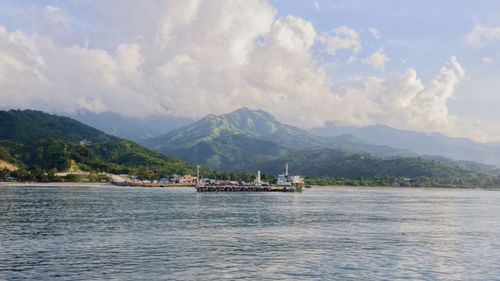 Scenic view of sea and mountains against sky