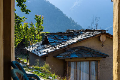 House amidst trees and buildings against sky