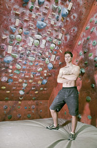 Full length portrait of man standing against wall