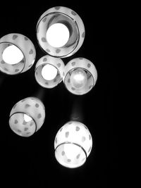 Close-up of illuminated lighting equipment against black background