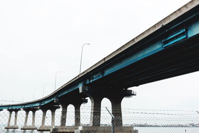 Low angle view of bridge over river against clear sky