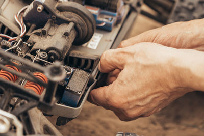 Cropped hands repairing machine part