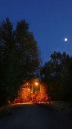 Illuminated street light against clear sky at night