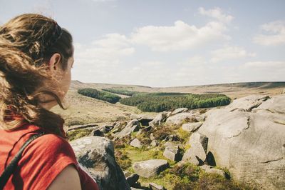 Rear view of woman standing on mountain landscape