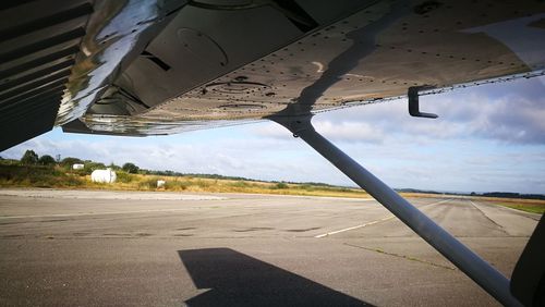 Airplane on runway against sky