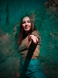 Portrait of a smiling woman standing against waterfall