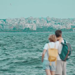 Rear view of couple standing against sea