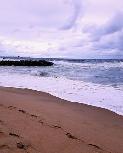 View of beach against cloudy sky