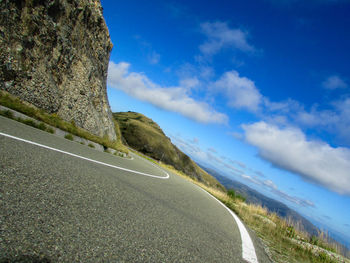 Road amidst land against sky