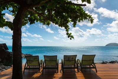 Pier on sea against cloudy sky