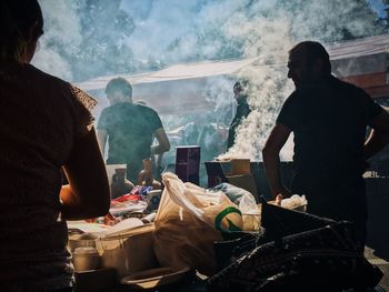 Rear view of people standing on mountain against sky