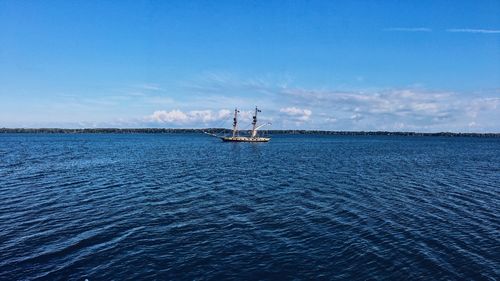 Sailboat sailing on sea against blue sky