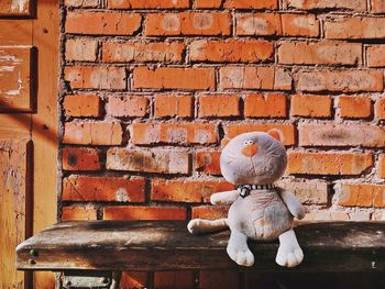 Close-up of stuffed toy against brick wall