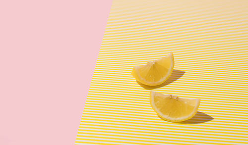 Creative summer layout made of lemon on yellow and bright pastel pink background. minimal concept.