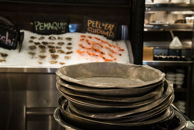 Stack of pewter dishes on counter in commercial kitchen at restaurant