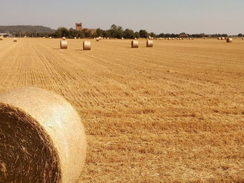 Hay bales on field against sky