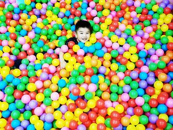 High angle portrait of smiling boy in ball pool