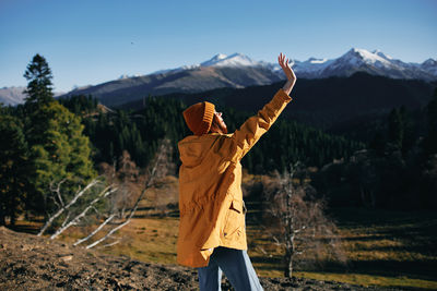 Rear view of woman standing against mountain