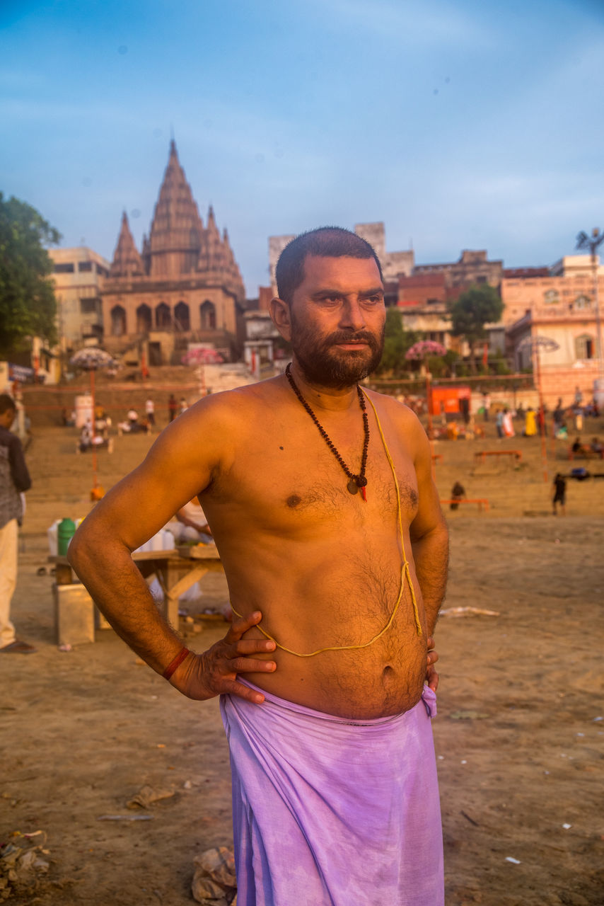 architecture, building exterior, one person, built structure, real people, lifestyles, incidental people, standing, leisure activity, history, casual clothing, front view, young adult, focus on foreground, the past, city, men, mid adult, young men, outdoors