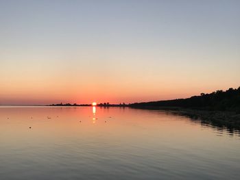 Scenic view of lake against clear sky during sunset