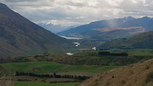 Scenic view of valley and mountains against sky