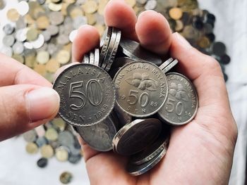 Close-up of hands holding coins over table