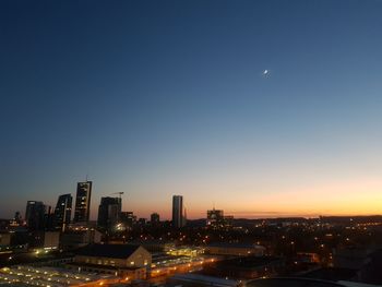 Illuminated city against sky at night